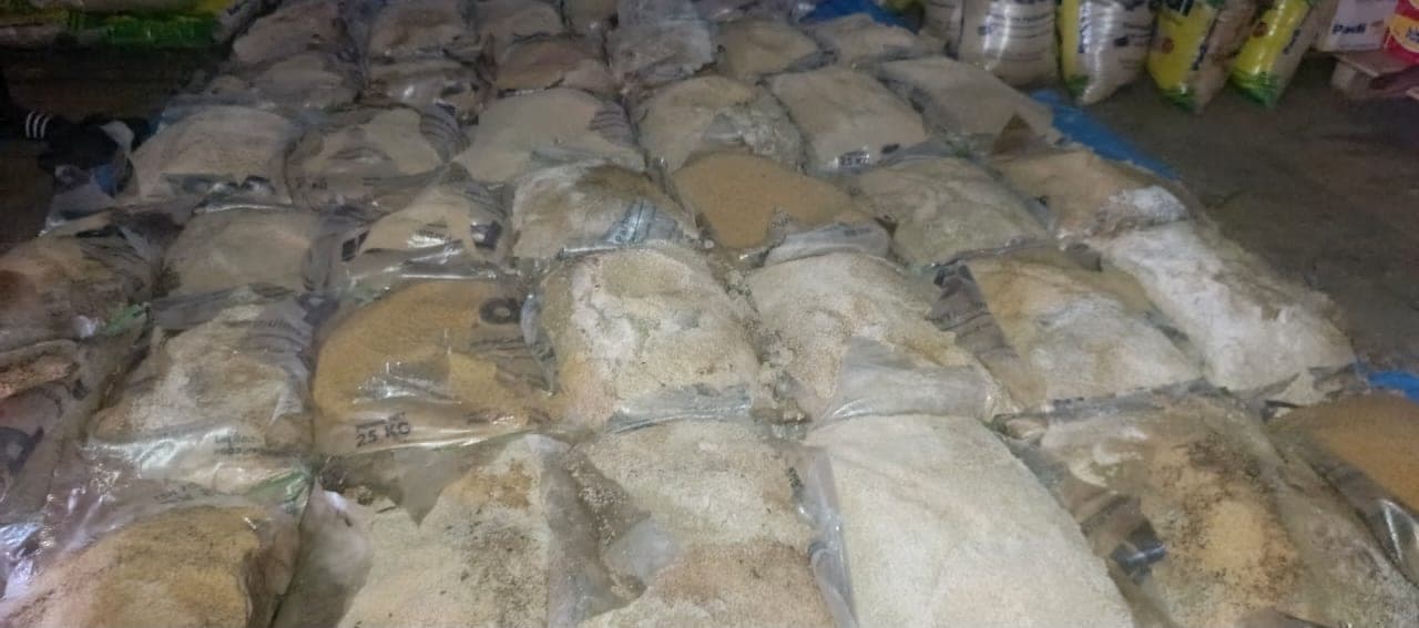 Bulk bagged cargo laid out on a warehouse floor for inspection