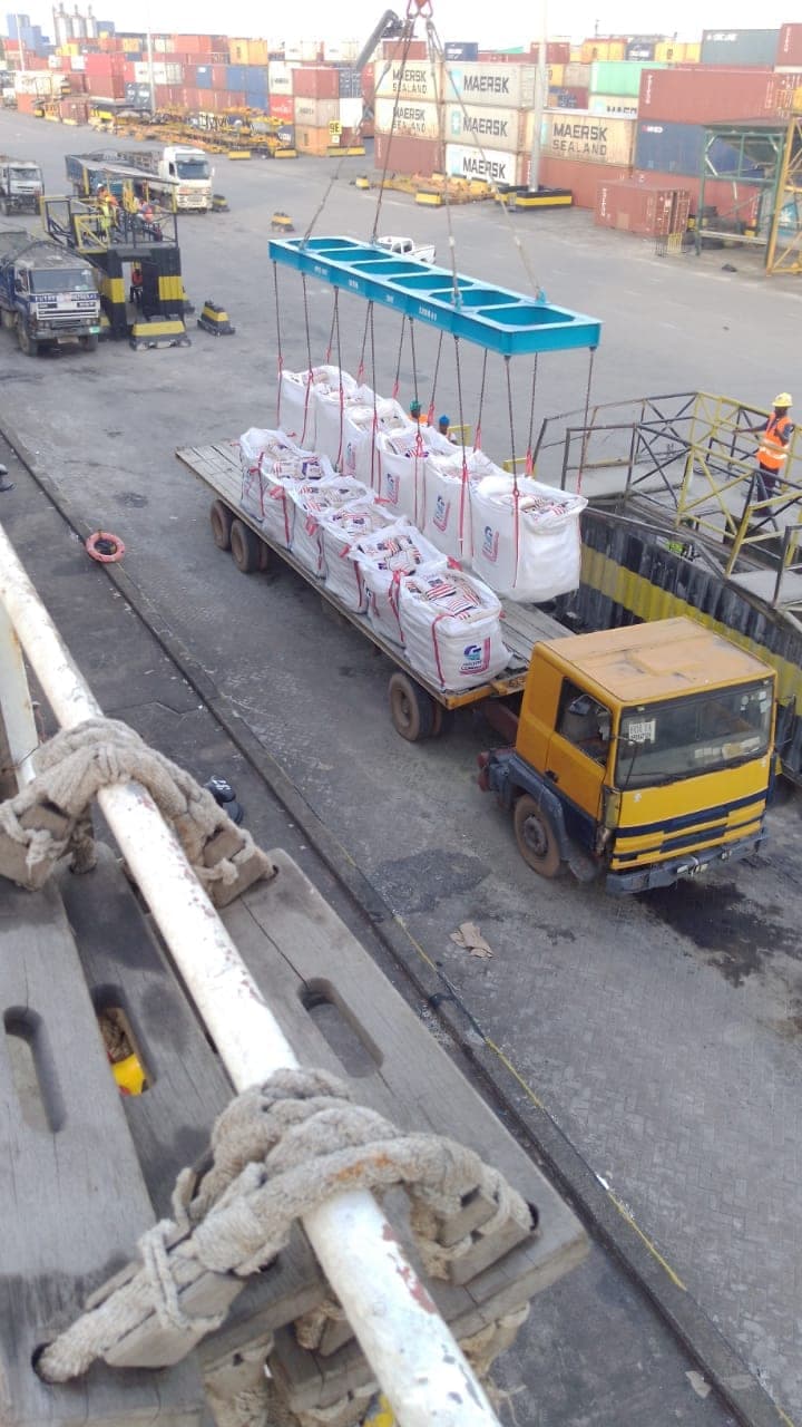 Crane lifting bagged cargo at a container port