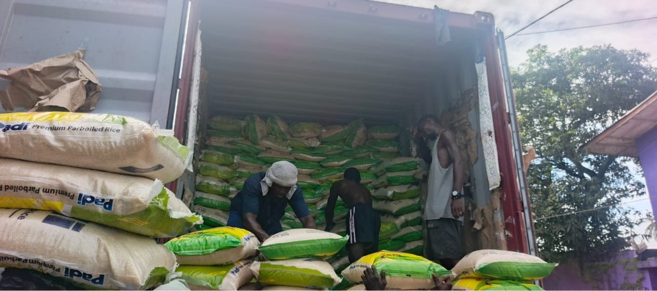 Workers loading bagged rice cargo into a container during discharge tally