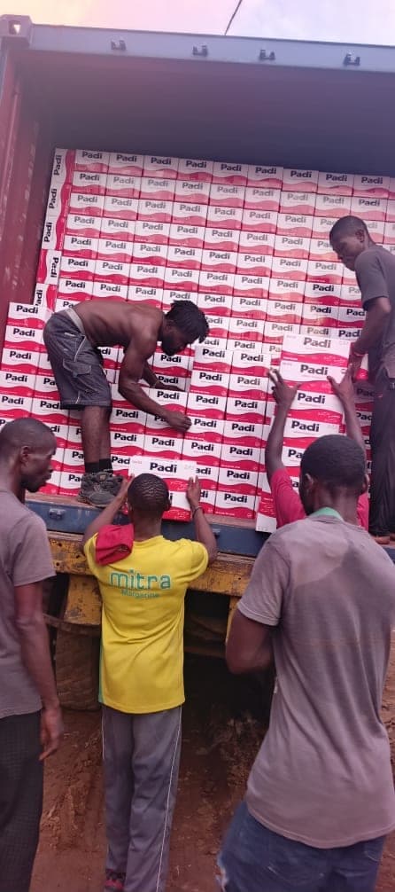 Workers tallying and loading boxed cargo into a container