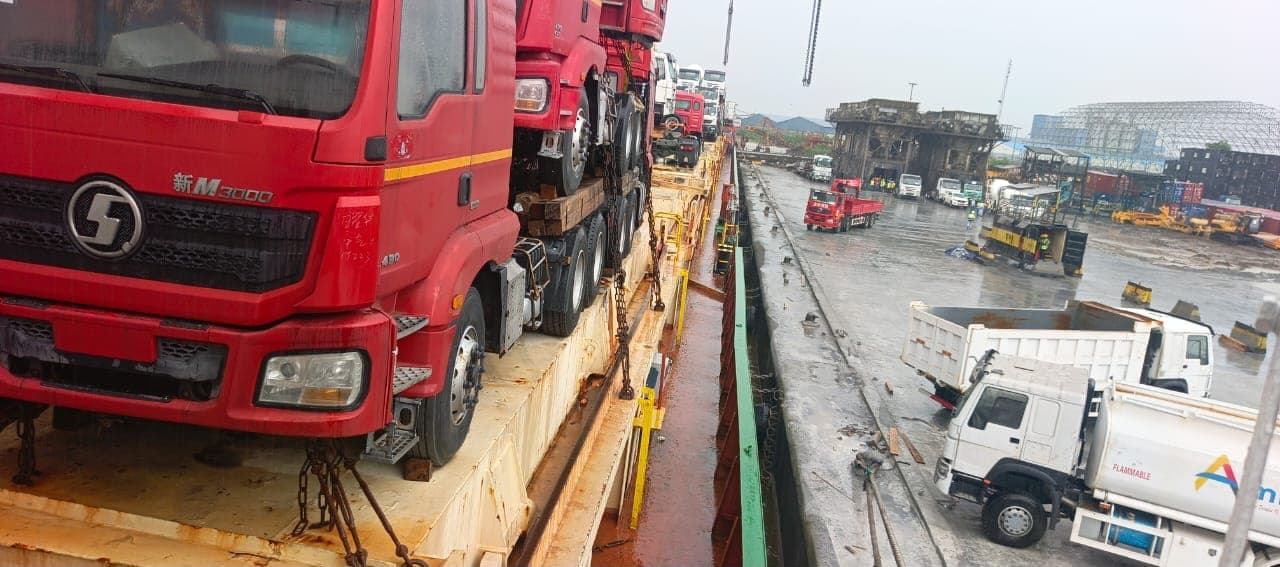 Heavy vehicles secured on a vessel deck for transport