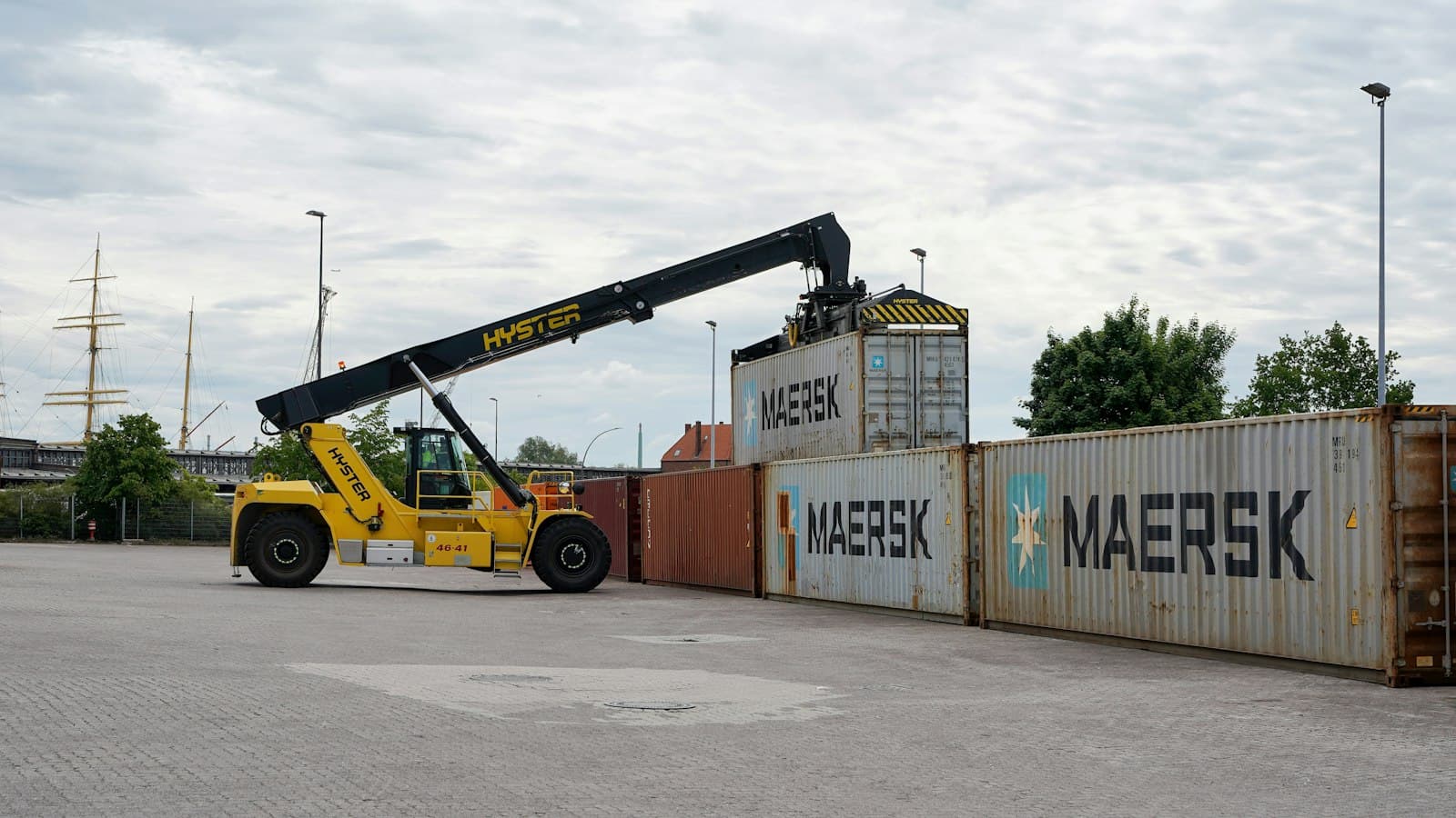 Reach stacker lifting a shipping container at a port yard